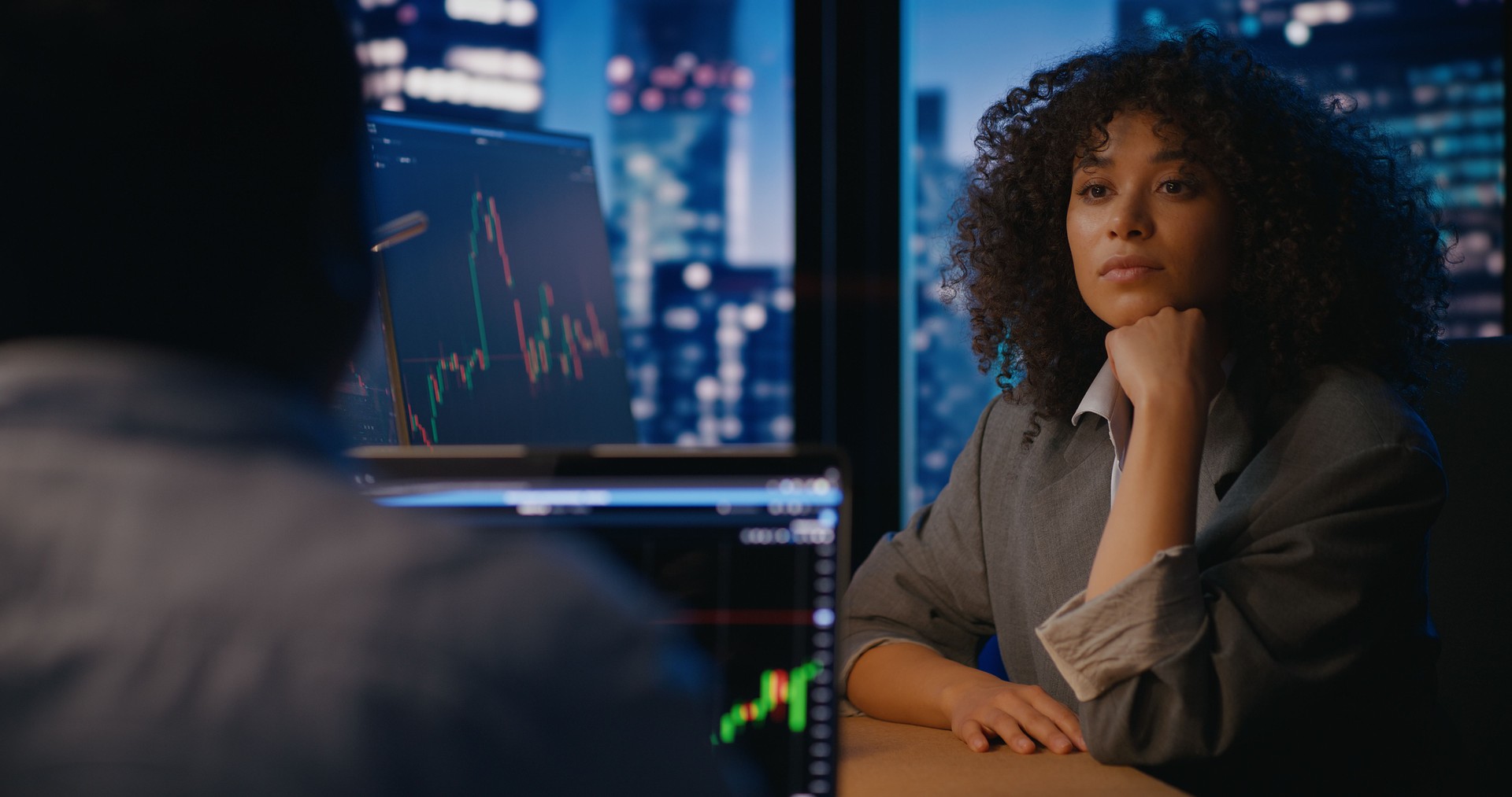 Female sitting in the office listening and talking to the colleague as they discuss an important matter